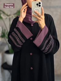 Close-up of black abaya with mauve embroidery