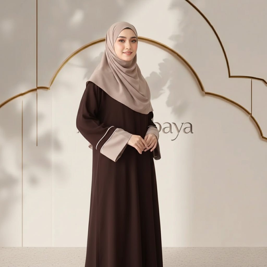 Woman wearing a brown dress with a beige hijab against a neutral background with 'baya' branding.