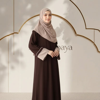 Woman wearing a brown dress with a beige hijab against a neutral background with 'baya' branding.