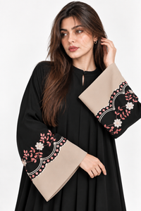 Black abaya front pose with hand on face and matching kangoora embroidered cuffs