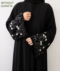 Close-up of black abaya with white floral embroidery